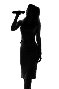 bir kadının elinde bir mikrofon ile şarkı silüeti