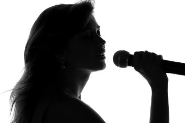 bir kadının elinde bir mikrofon ile şarkı silüeti