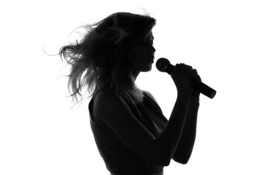 bir kadının bir mikrofonla şarkı silüeti