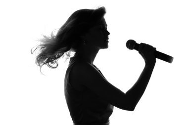 bir kadının bir mikrofonla şarkı silüeti