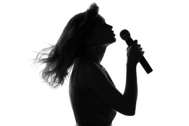 bir kadının bir mikrofonla şarkı silüeti