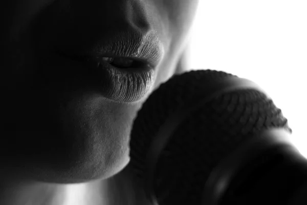 Silhouet van een vrouw zingen met een microfoon in handen — Stockfoto