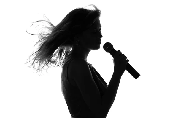 Silhouet van een vrouw zingen met een microfoon — Stockfoto