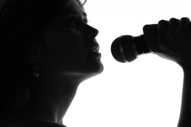 bir kadının elinde bir mikrofon ile şarkı silüeti