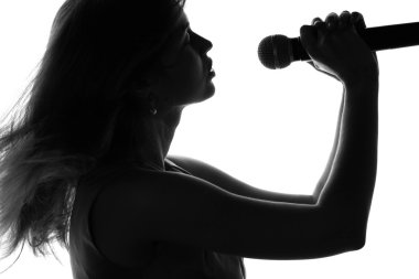 bir kadının elinde bir mikrofon ile şarkı silüeti