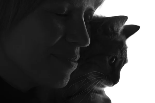 Silhueta de uma mulher abraçando um gato — Fotografia de Stock