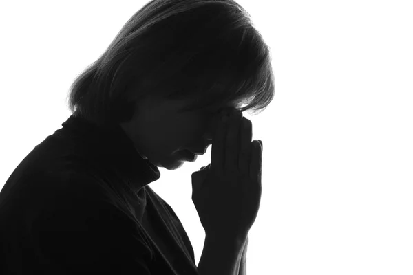 Retrato aislado en blanco y negro de una mujer con las manos dobladas cerca del puente de la nariz debido a la desesperación —  Fotos de Stock