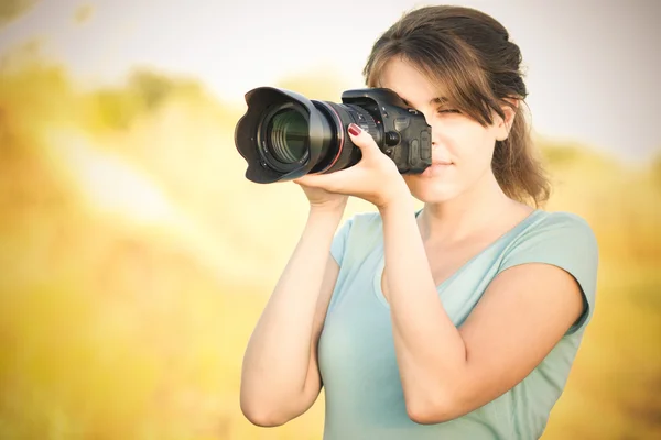 Fotografie mladé ženy fotografka s fotoaparátem v ruce — Stock fotografie