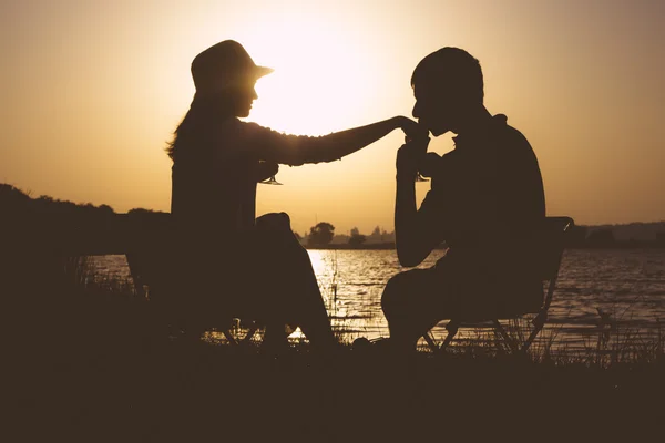 Sylwetka powołania młodych par w miłości do opuszczenia na piknik z miasta o świcie — Zdjęcie stockowe