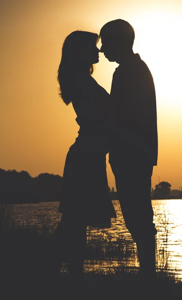 Silhueta de jovens casais felizes ao amanhecer no rio — Fotografia de Stock