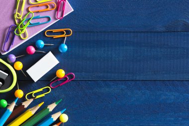 metin yazmak için boşluk ile masaya yatan ataş, iğne, defter, kalem, kalem, cetvel, makas gibi okul kırtasiye çeşitleri