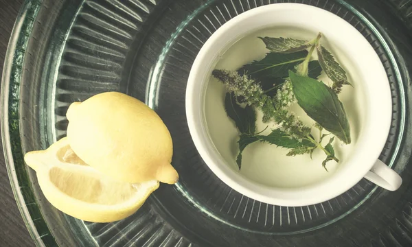 Foto von grünem Tee mit Minze und Melissenblüten in einem weißen Cu — Stockfoto