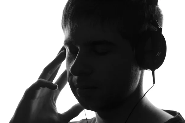 一个少年在大耳机里听音乐的黑色和白色的肖像 — 图库照片
