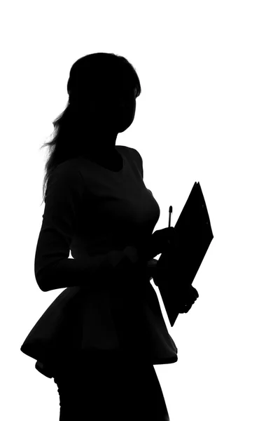 Silhouette di una donna che lavora in un ufficio con una cartella per fogli e una penna nelle mani — Foto Stock