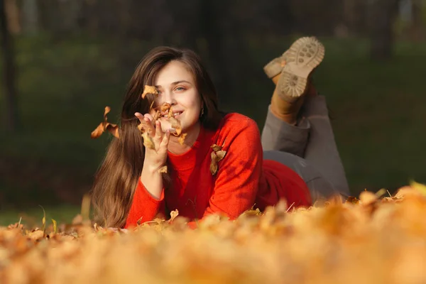 森の紅葉の上に横たわる幸せな女性屋外の女の子の肖像画 — ストック写真