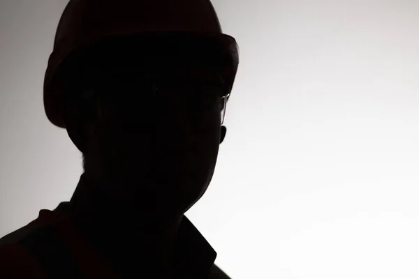 face silhouette of builder in hard hat on white isolated background, male profession concept