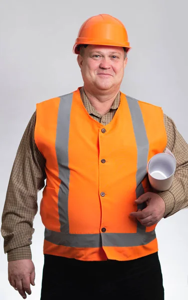 快乐而肥胖的建筑工人 身披硬礼帽 身披灰色工作室背景 快乐的工程师 腋下夹着一卷文件 — 图库照片