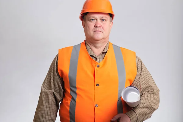 建筑工人 肚子饿 头戴硬礼帽 背景灰暗 心情愉快的工程师建筑师 腋下夹着一卷文件 — 图库照片