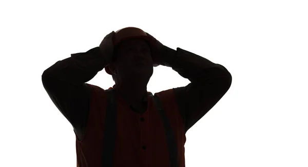 白い背景にヘルメットで頭をクラッチ建設労働者の暗いシルエットストレスの中で隔離された背景に 作業の進行を懸念フォアマン — ストック写真