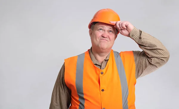 灰蒙蒙的工作室背景下戴着帽子的胖建筑工人 工头灰心丧气 — 图库照片