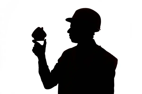 Silhouette Des Bauarbeiters Helm Hält Kleine Figur Der Hausmaquette Auf — Stockfoto