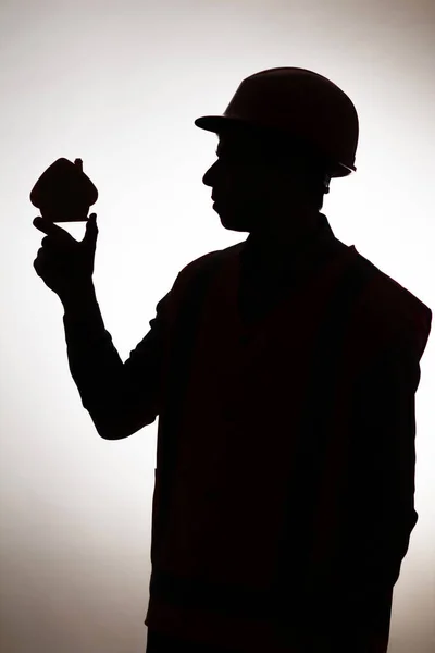 헬멧을 일하는 봉사자의 실루엣으로 놓여져 개념을 구축하고 — 스톡 사진