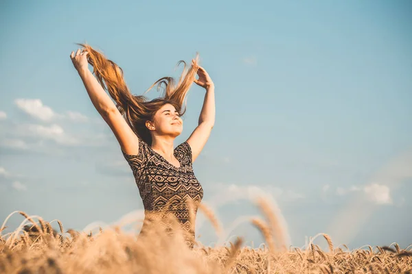 自然を楽しむ幸せな若い女性小麦畑の曇り空を背景に手を上げ女の子は深く呼吸自由とリラクゼーションの概念 — ストック写真