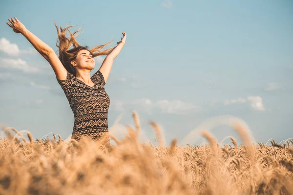 自然を楽しむ幸せな若い女性小麦畑の曇り空を背景に手を上げ女の子は深く呼吸自由とリラクゼーションの概念 — ストック写真