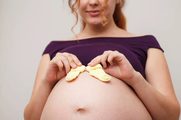 Jovem Bela Mãe Expectante Coloca Meias Criança Pequena Sua Barriga — Fotografia de Stock
