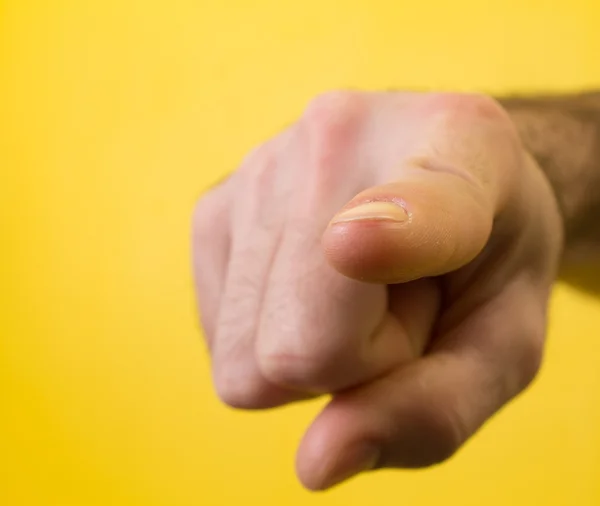 Mano masculina con el dedo apuntando o haciendo gestos hacia ti sobre fondo amarillo — Foto de Stock