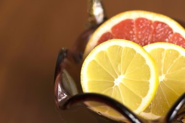 Dilimlenmiş Greyfurt ve limon bir vazo içinde yalan