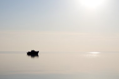 Gün batımında kayan bir teknenin siluet