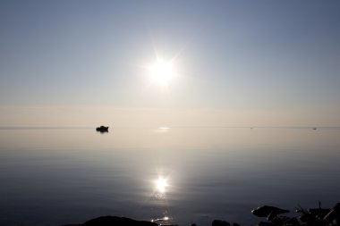 Gün batımında kayan bir teknenin siluet