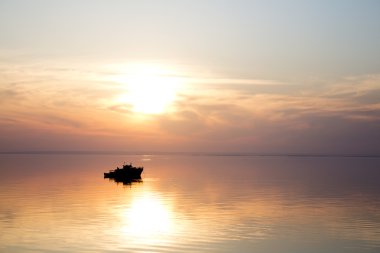 Gün batımında kayan bir teknenin siluet
