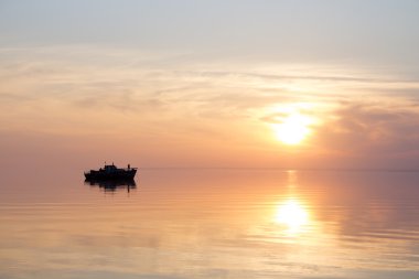 Gün batımında kayan bir teknenin siluet