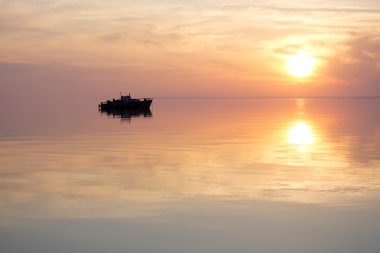 Gün batımında kayan bir teknenin siluet
