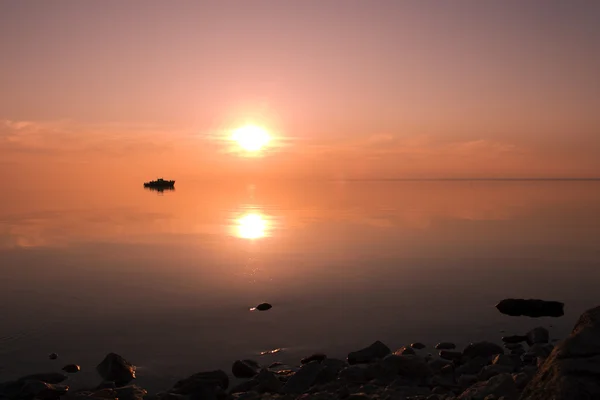 Silhouette eines schwimmenden Bootes bei Sonnenuntergang — Stockfoto