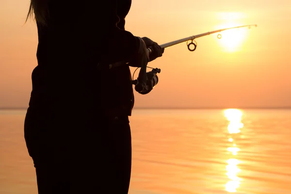 Niña pescando al atardecer cerca del mar — Foto de Stock