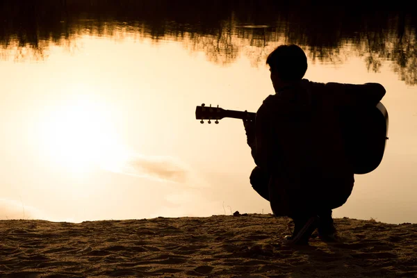 ギターとビーチで若い男のシルエット — ストック写真