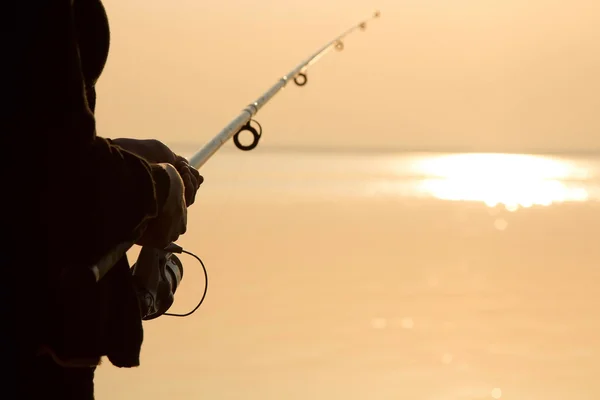 Силуэт рыбака на закате у моря с удочкой — стоковое фото