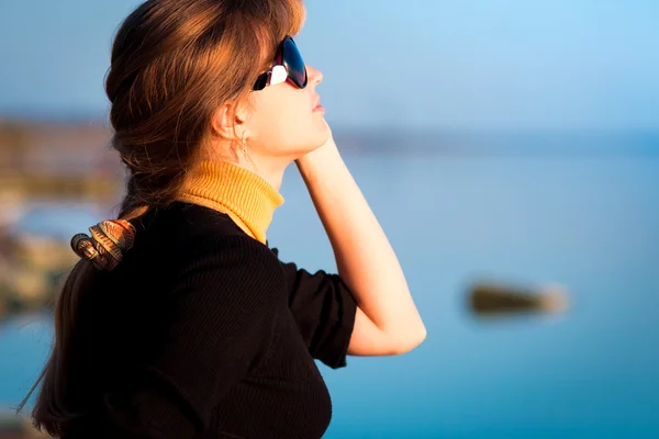 Porträtt av en vacker flicka i solglasögon på Älvstranden — Stockfoto