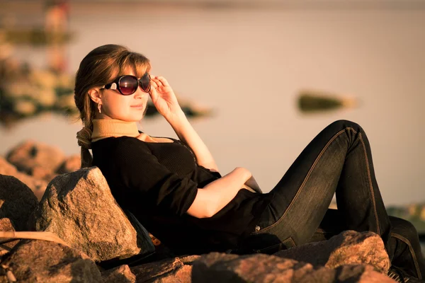 Portret van een mooi meisje in zonnebril op de rivier bank — Stockfoto