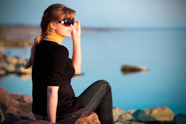 Portret van een mooi meisje in zonnebril op de rivier bank — Stockfoto