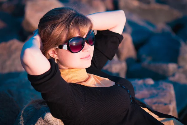 Portrait of a beautiful girl in sunglasses on the rocks — Stock Photo, Image