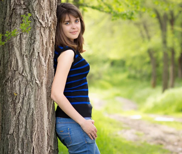 Mooi meisje in de buurt van een boom in het voorjaar — Stockfoto