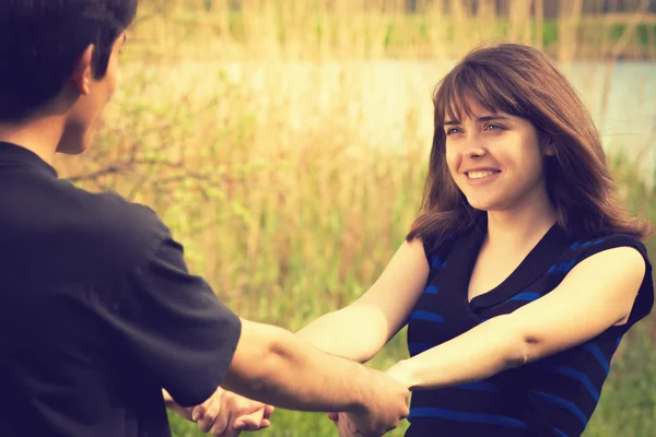 Young couple joined hands spinning in nature — Stock Photo, Image