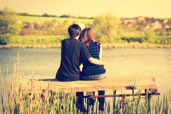 Vintage photo of couple embraces on the pier at the river bank — Stock Photo, Image