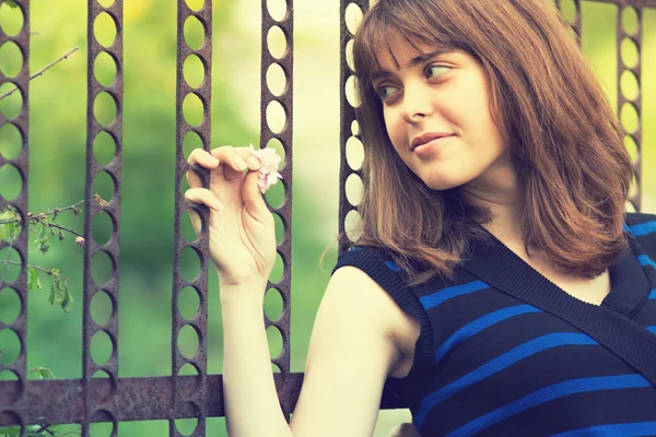Portrait of a girl holding hands on the gate — Stock Photo, Image