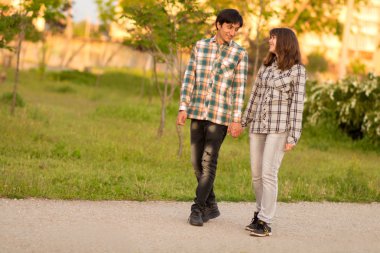 sevgi dolu çift baharda bir şehir parkında yürüyüş