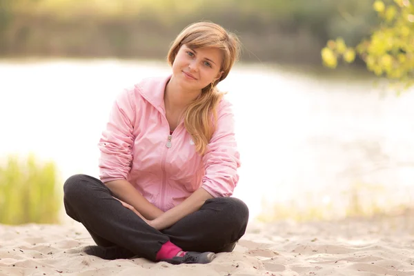 Mooi meisje, zittend op het zand — Stockfoto